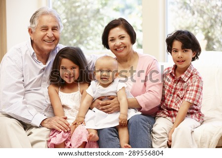 Hispanic grandparents at home with grandchildren