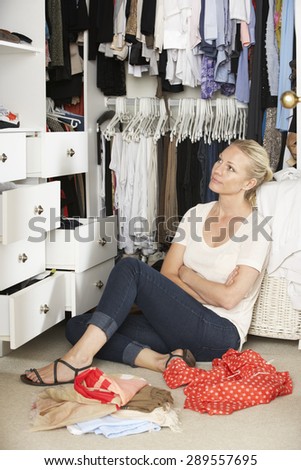 Teenage Girl Choosing Clothes From Wardrobe In Bedroom