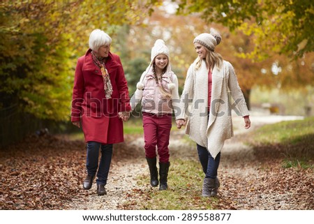 Female Multl Generation Family Walking Along Autumn Path