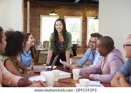 Female Boss Addressing Office Workers At Meeting