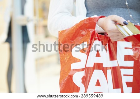 Close Up Of Shopper Holding Credit Card And Bag In Mall