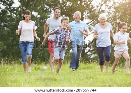 Multi Generation Family Running Across Field Together