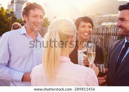 Colleagues drinking after work at a rooftop bar