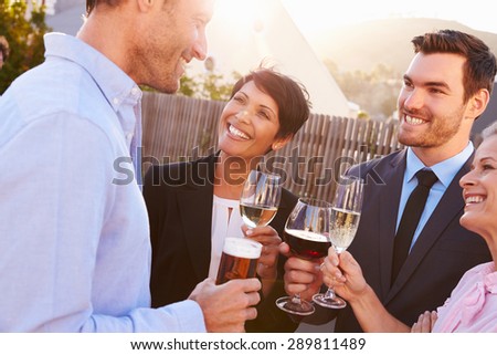 Colleagues drinking after work at a rooftop bar