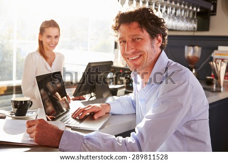 Male restaurant manager working on laptop