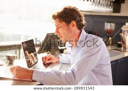 Male restaurant manager working on laptop