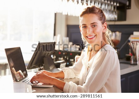 Female restaurant manager working at counter