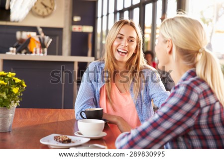 Two female friends talking at a coffee shop