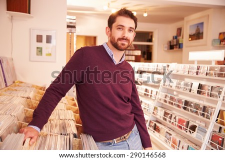 Shop owner posing in a record shop