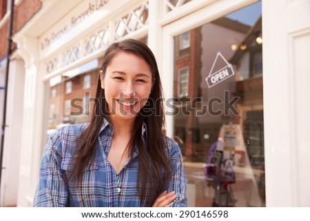 Shop owner standing next to her shop