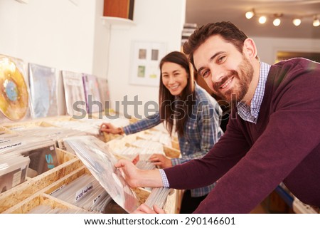 Two people browsing records at a record shop, portrait