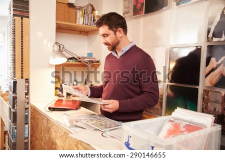 Man working behind the counter at a record shop, portrait