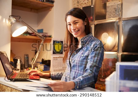 Young woman working behind the counter at a record shop