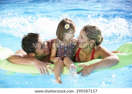Family On Holiday In Swimming Pool