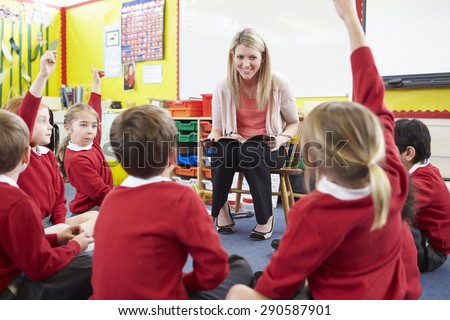 Teacher Reading Story To Elementary School Pupils