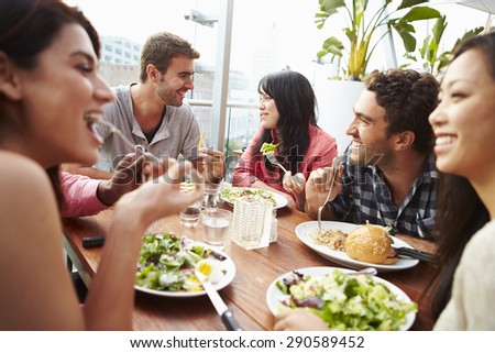 Group Of Friends Enjoying Meal At Rooftop Restaurant