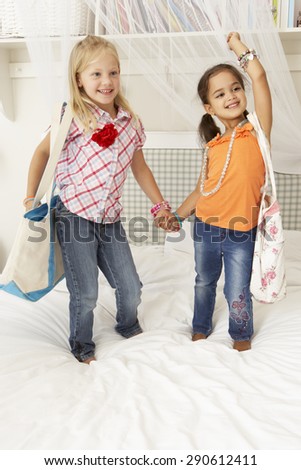 Two Young Girls Dressing Up Together In Bedroom
