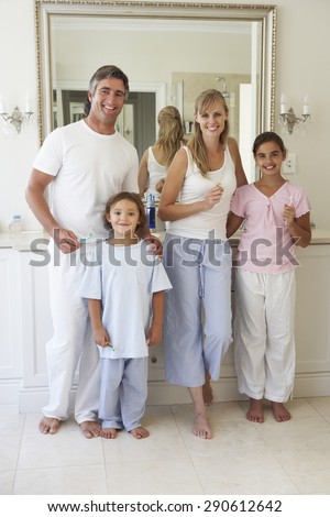 Portrait Of Family About To Brush Teeth In Bathroom Mirror