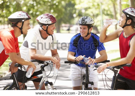 Group Of Men Resting During Cycle Ride Through Park