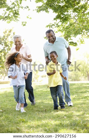 African American Grandparents With Grandchildren Walking In Park