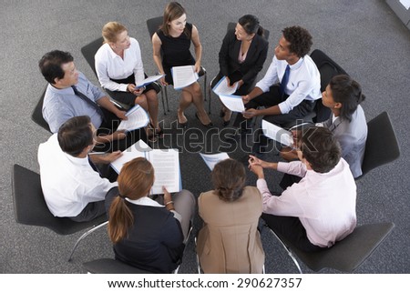 Overhead View Of Businesspeople Seated In Circle At Company Seminar