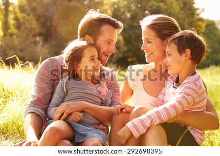 Family relaxing together outdoors, looking at each other