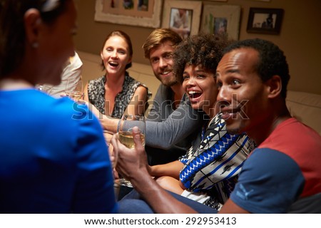 Group of friends sitting around a table at house party