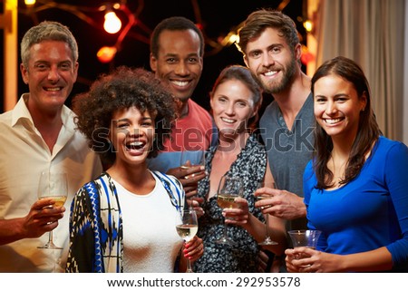 Adult friends drinking at a house party, group portrait