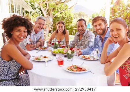 Friends dining together at a table in a garden
