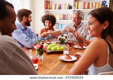 Friends sitting at a table talking during a dinner party