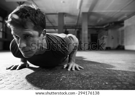 Black And White Shot Of Man In Gym Doing Press-Ups