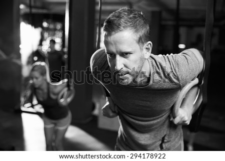 Black And White Shot Of Man Exercising With Gymnastic Rings