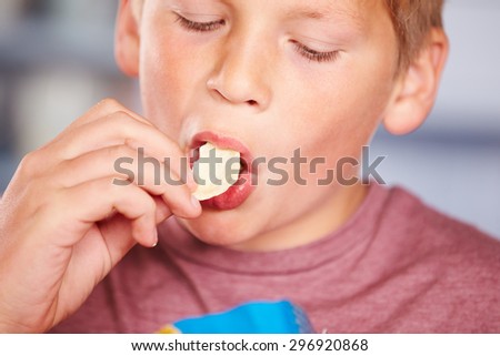 Close Up Of Boy Eating Packet Of Potato Chips