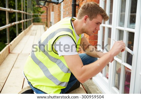 Decorator On Scaffolding Painting Exterior House Windows