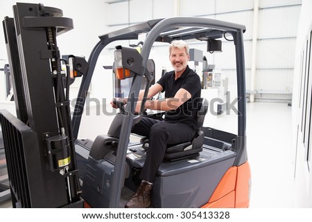 Portrait Of Male Fork Lift Truck Driver In Factory