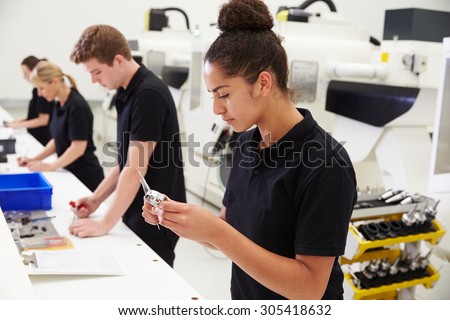 Workers In Engineering Factory Checking Component Quality