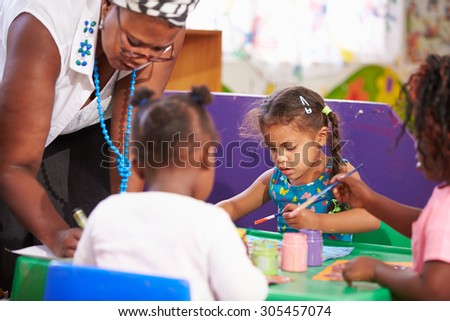 Teacher helping kids in a preschool class, close up