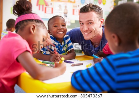 Volunteer teacher helping a class of preschool kids drawing