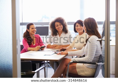 Casually dressed female colleagues talking in a meeting room