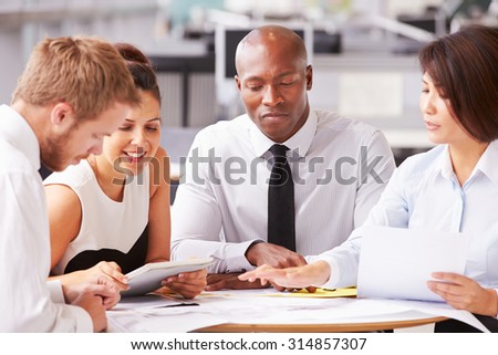 Four office colleagues in a casual team meeting