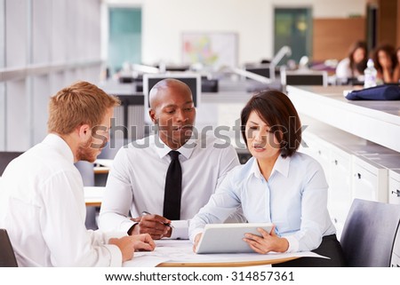Three office colleagues in a casual team meeting
