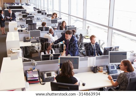 Manager in discussion with coworker in an open plan office