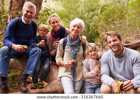 Multi-generation family eating in a forest, portrait