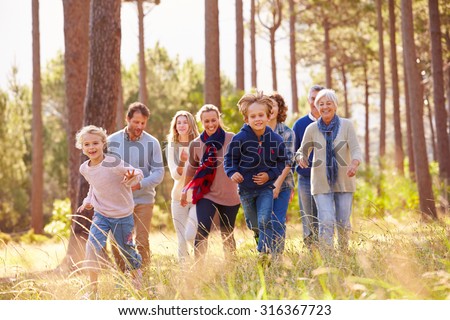 Multi-generation family walking in countryside, kids running
