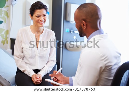 Female Patient And Doctor Have Consultation In Hospital Room