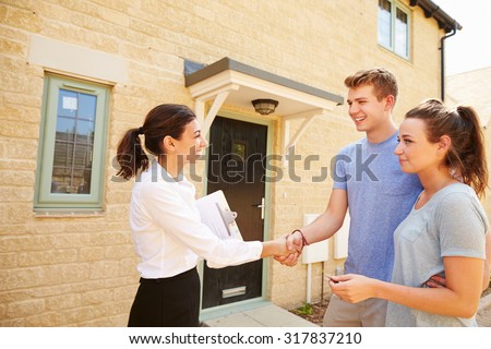 Real estate agent shaking hands with new property owners