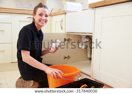 Female plumber holding a u-bend pipe for a kitchen sink