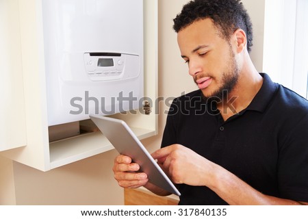 Technician servicing a boiler using tablet computer
