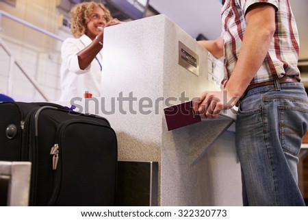Passenger Weighing Luggage At Airport Check In