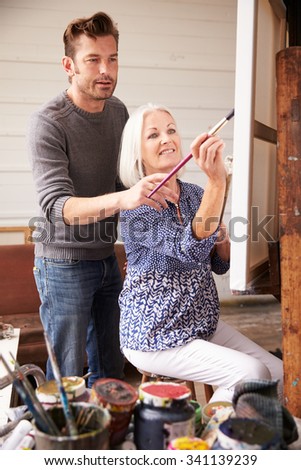 Artist With Female Student In Painting Class